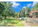Spacious backyard featuring a pool, deck, mature trees, and play area, perfect for outdoor enjoyment at 4656 Bryant Rd, Snellville, GA 30039