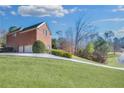 Long driveway leading to a two-car garage showcasing a sprawling lawn and mature trees at 2025 Fife Ridge Ct, Roswell, GA 30075