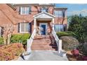 Inviting front entrance with brick steps, a white railed staircase and landscaped bushes and flowerbeds at 2025 Fife Ridge Ct, Roswell, GA 30075