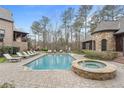 Inviting pool area with lounge chairs, hot tub, and meticulously designed patio at 918 Big Horn Holw, Suwanee, GA 30024