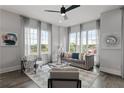 Living room with hardwood floors, gray couch, and large windows at 244 Castleberry Station Sw Dr, Atlanta, GA 30313