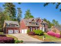 Charming brick home with a three car garage and a well-maintained lawn at 701 Vinings Estates Se Dr, Smyrna, GA 30126