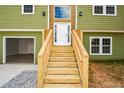 Wooden stairs and railing leading to the front door of a green house at 153 Oak St, Hiram, GA 30141