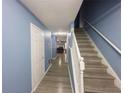 Hallway features modern flooring, fresh paint, and staircase leading to upper level at 8045 Woodlake Dr, Riverdale, GA 30274