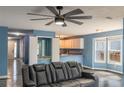 Open-concept living area with modern ceiling fan and convenient bar area that connects to kitchen at 8045 Woodlake Dr, Riverdale, GA 30274