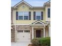 Two story townhome with yellow siding, stone accents, and a two car garage at 4940 Parke Brook Dr, Acworth, GA 30101