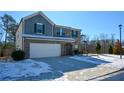 Two-story brick home with a white garage door and snowy front yard at 129 Warbler Way, Mcdonough, GA 30253