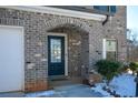 Home's entryway with a dark blue door and brick archway at 129 Warbler Way, Mcdonough, GA 30253