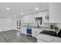 Bright kitchen boasts white cabinets, stainless steel appliances, granite countertops, and modern flooring at 5774 Forest Dr, Acworth, GA 30102
