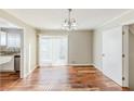 Dining room features hardwood floors, a modern chandelier, and sliding glass doors at 3670 Leisure Ln, Atlanta, GA 30349