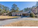 Well-maintained home with a long driveway and a covered carport, surrounded by mature trees at 2424 West Rd, Riverdale, GA 30296