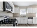 Modern kitchen featuring white cabinets, stainless steel appliances, and granite countertops at 2424 West Rd, Riverdale, GA 30296