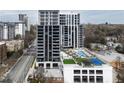 Modern high-rise condo building with a rooftop pool, lounge area, and green space for leisure at 2425 Peachtree Rd # 508, Atlanta, GA 30305