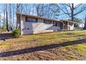 Well-kept one-story brick home with a tidy lawn, complemented by mature trees and a blue storage shed at 4388 Coleman Dr, Stone Mountain, GA 30083