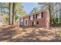 Charming two-story brick home with an attached garage, and a large driveway nestled among mature trees at 5938 Baywood Ln, Riverdale, GA 30296