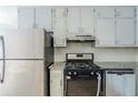 Features in the kitchen include stainless steel appliances, white cabinets, granite countertops, and tile backsplash at 920 Navajo Trl, Covington, GA 30016