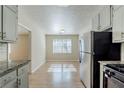Open kitchen view with stainless steel refrigerator and a view of the light-filled dining area at 920 Navajo Trl, Covington, GA 30016