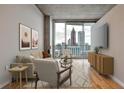 Contemporary living room featuring hardwood floors and large windows showcasing city skyline views at 860 Peachtree Ne St # 2506, Atlanta, GA 30308