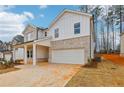 New construction featuring a two-car garage, a mix of brick and vertical siding, and professionally landscaped grounds at 261 Martin Spring Rd, Lawrenceville, GA 30045