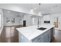 Bright, open kitchen featuring white cabinets, quartz countertops, an island, and stainless steel appliances at 883 Gaston Sw St, Atlanta, GA 30310