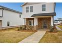 Inviting two-story home with stone accents, covered entrance, and concrete walkway to the front door at 1260 Firefly Field Trce Trce, Lawrenceville, GA 30045