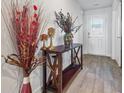 Bright entryway with decorative console table and hardwood floors at 909 Teabiscuit Way, Mcdonough, GA 30253
