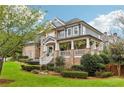 Brick and siding home with a wraparound porch and lush landscaping at 3051 Oglethorpe Ne Way, Brookhaven, GA 30319