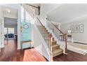 Two-story foyer with hardwood floors, wooden staircase, and a unique decorative door at 8630 Amsbury Way, Cumming, GA 30041