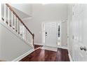 Bright entryway with hardwood floors, white front door, and staircase at 8630 Amsbury Way, Cumming, GA 30041