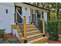 Modern wooden stairs with black metal railings leading to the front door at 1770 Austin Dr, Decatur, GA 30032
