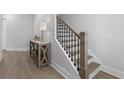 Modern staircase with dark wood and metal railing, light walls, and hardwood floors at 2133 Kirkham Way, Kennesaw, GA 30152