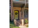 Brick front entrance with a yellow door, steps, and landscaping at 9060 Selborne Ln, Chattahoochee Hills, GA 30268