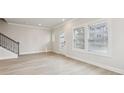 Bright, airy living room with wood floors, neutral walls, staircase, and a glass panel door at 4235 Holland Grove Rd, Lawrenceville, GA 30044
