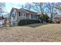 Side view of ranch home showcasing green shutters and a well-maintained lawn at 141 Hill St, Roswell, GA 30075