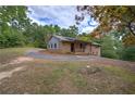 A brick home with a covered front porch surrounded by a grass yard and mature trees at 72 Bishop Nw Dr, Cartersville, GA 30121