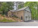 Spacious home featuring brick exterior, multiple garage parking, a stone staircase, and a lush green landscape at 4540 Club Valley Ne Dr, Atlanta, GA 30319