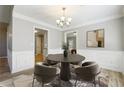 Elegant dining room with modern chandelier, round table, and wainscoting at 20 Trace Ct, Covington, GA 30016