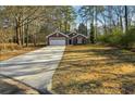 Front exterior of a red brick home with a long driveway leading to an attached two-car garage at 20 Trace Ct, Covington, GA 30016