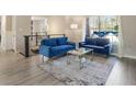 Elegant living room with blue sofas, a coffee table, and a large window at 4064 Chimney Ridge Way, Ellenwood, GA 30294