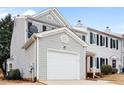 Two-story townhome with gray siding, brick accents, and a white garage door at 132 Timber Mist Ln, Lawrenceville, GA 30045