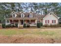 Two-story house with a wraparound porch and landscaped yard at 2020 Temple Johnson Rd, Loganville, GA 30052