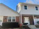 Two-story townhouse showcasing brick accents, neutral siding, and a well-manicured front yard at 5950 Wintergreen Rd, Norcross, GA 30093