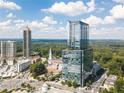 Aerial view of a modern high-rise residential building surrounded by trees on a sunny day at 3630 Peachtree Ne Rd # 2104, Atlanta, GA 30326
