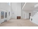 Bright living room with tall ceilings, a fireplace, large windows, and unfinished hardwood floors at 4271 Matisse Ln, Fairburn, GA 30213