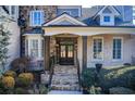 Inviting front porch with stone steps, dark wooden door and decorative columns at 171 Johnson Ferry Nw Rd, Atlanta, GA 30328