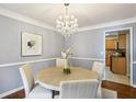 Bright dining room featuring a modern chandelier, round table, hardwood floors, and a glimpse of the kitchen at 2947 Dunnington Cir, Chamblee, GA 30341