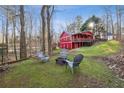 Charming backyard with a fire pit area, overlooking a beautifully constructed red barn-style building at 3970 Bridgeman Cir, Cumming, GA 30041