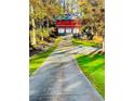 Long driveway leading to a stunning red barn-style building with three-car garage at 3970 Bridgeman Cir, Cumming, GA 30041