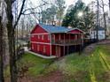 Exterior view of red barn-style building with a charming balcony and manicured lawn at 3970 Bridgeman Cir, Cumming, GA 30041