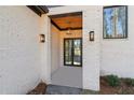 Covered front entry with brick facade, glass door, and modern light fixtures at 1820 Lake Dow Rd, Mcdonough, GA 30252